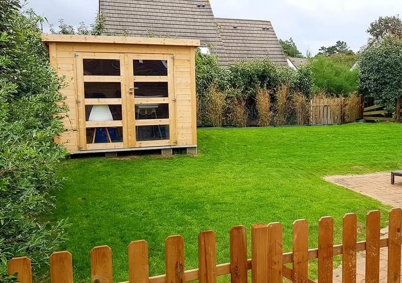 Pelouse impeccable et clôture en bois après une remise en état