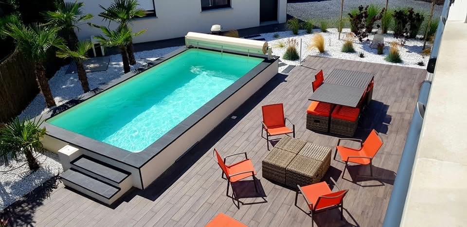 Piscine et terrasse bois entourées de palmiers, jardin contemporain sur la Côte d’Opale