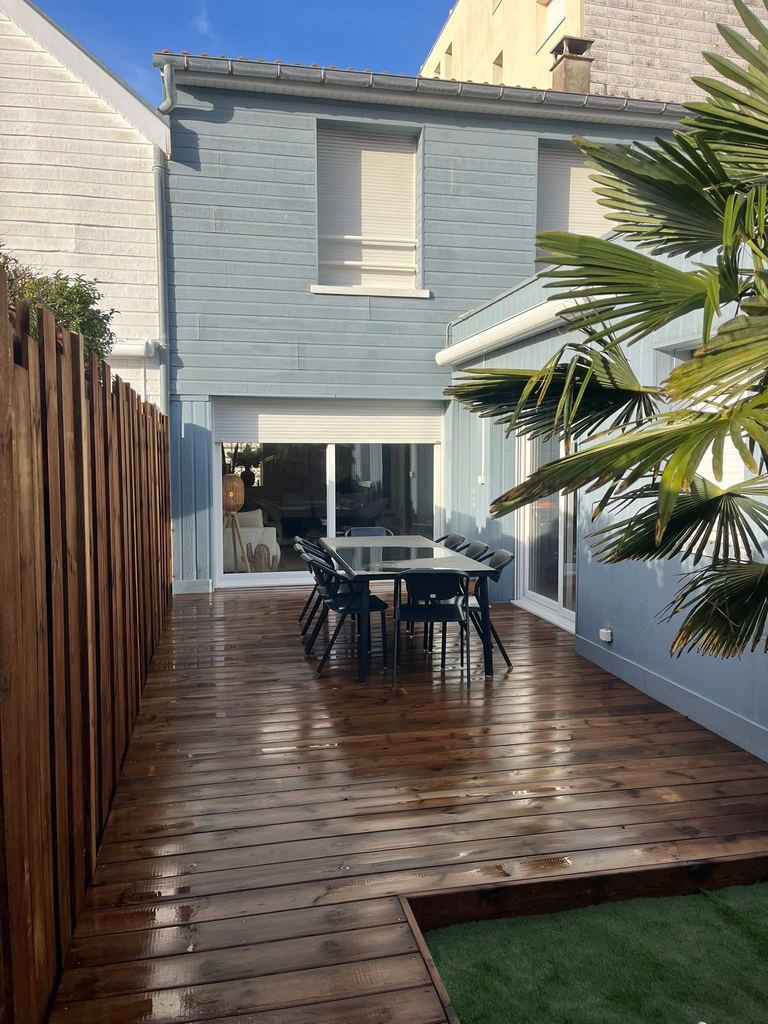 Terrasse bois sur un petit jardin de ville, palmier conservé