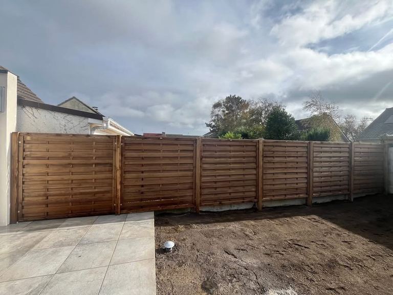 Après : Un jardin envahi, nettoyé, clôturé, prêt pour le gazon.