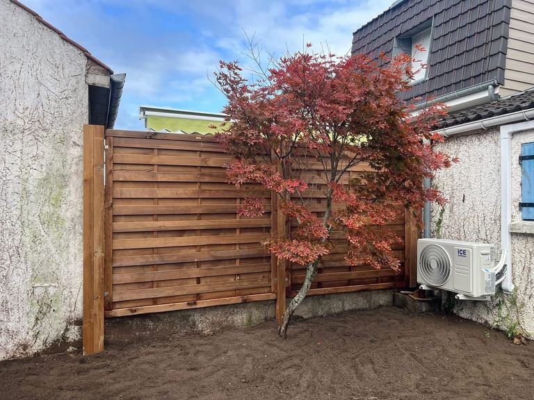Panneaux de clôture bois derrière un érable du Japon