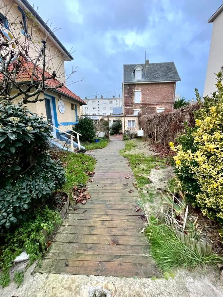 Avant : La terrasse d’un hôtel : pavés, clôture bois et éclairage