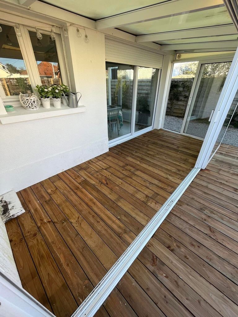 Le plancher bois sous la véranda, ouvert sur l’extérieur