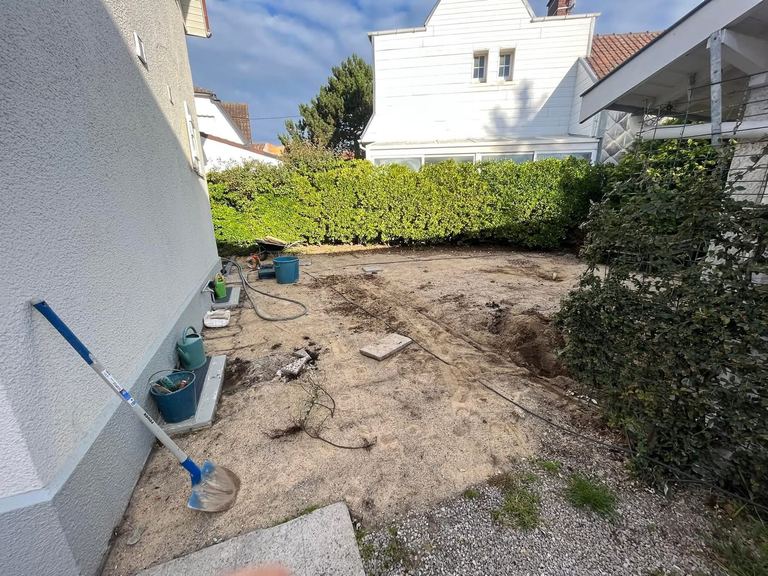 Avant : La cour arrière terrassée puis pavée, avec caniveau.