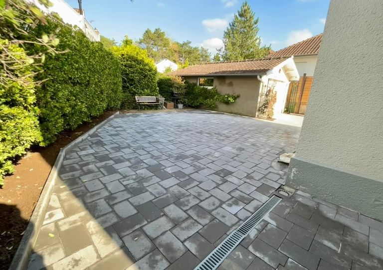 Après : La cour arrière terrassée puis pavée, avec caniveau.