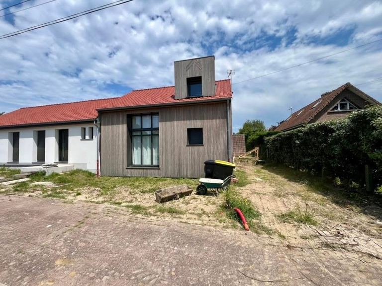 Avant : Le pignon côté rue : clôture en ganivelles de châtaignier et gazon en rouleau.