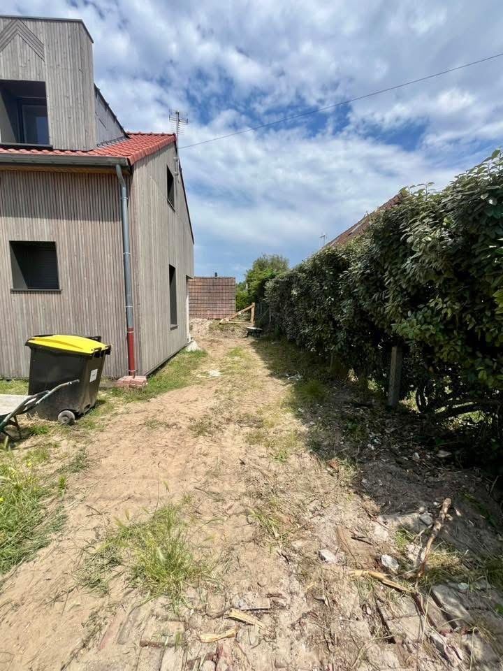 Avant : Le passage latéral : sable nu avant, escalier de traverses dans le gazon après.