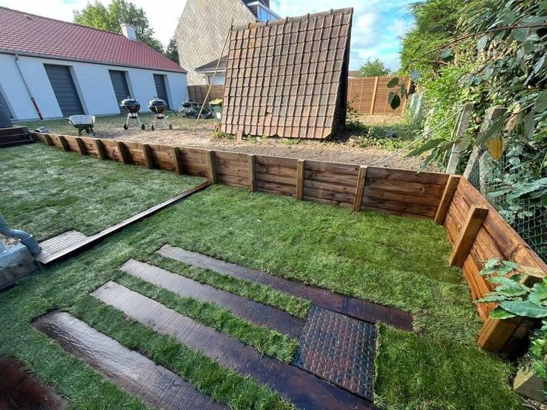 Gazon en rouleau fraîchement posé avec des marches en traverses bois