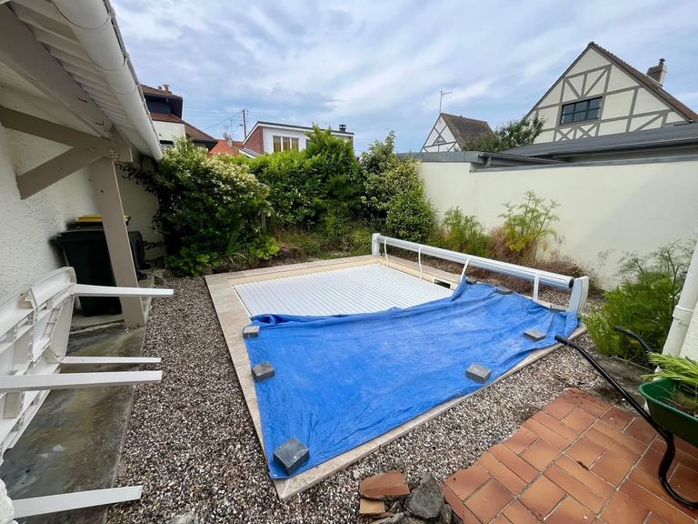 Avant : Les abords d’une piscine repris en dalles grès cérame, clôture bois neuve.
