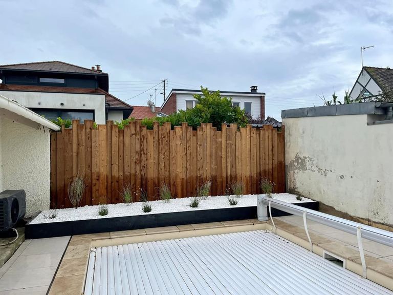 Clôture bois pleine hauteur derrière une piscine
