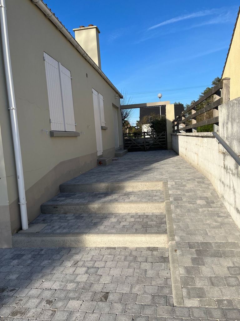 Allée pavée et marches le long d’une maison