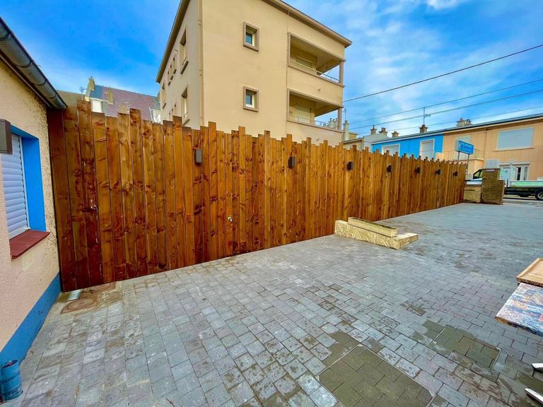 Terrasse pavée et clôture en lames bois