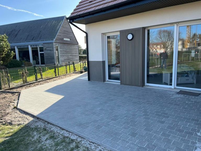 Terrasse en dalles devant une maison à bardage sombre