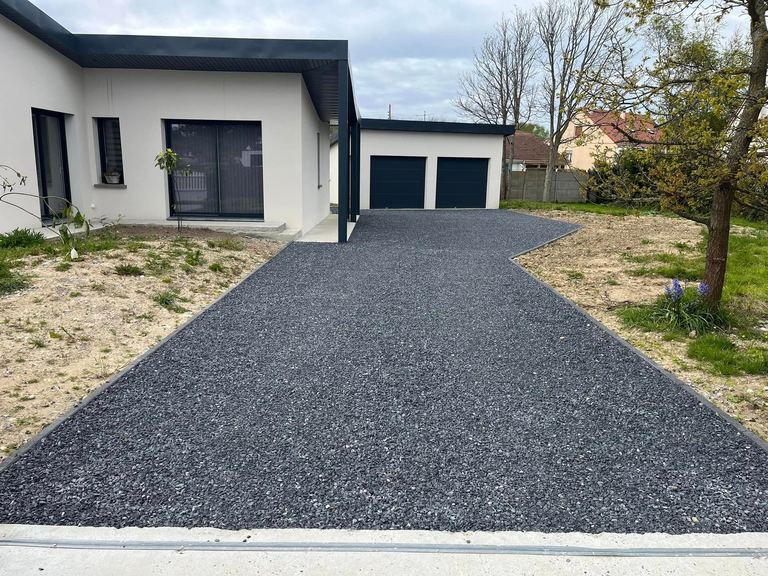 Cour en gravier anthracite devant une maison contemporaine